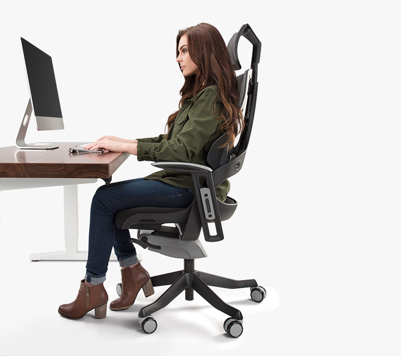 A woman in a stylish office chair working productively at a desk, demonstrating proper posture and comfort.