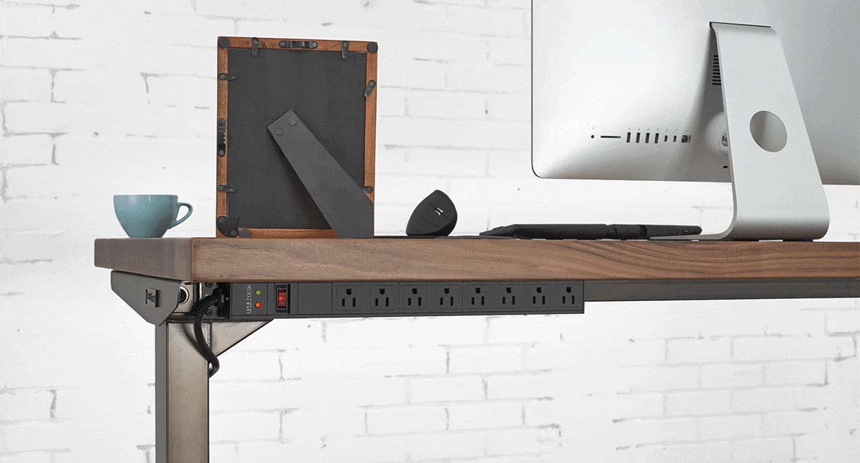 Surge Protector mounted to a desktop with downward-facing outlets.
