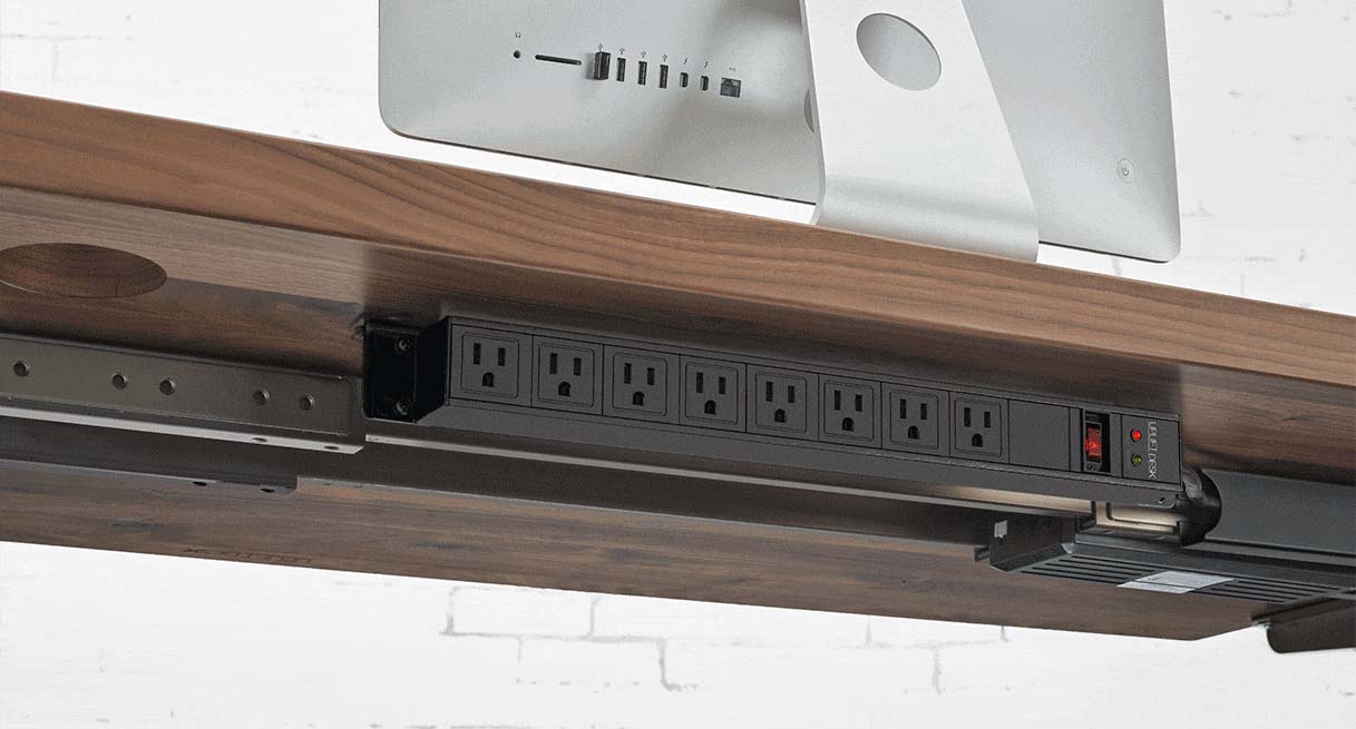 Surge Protector mounted to a desktop with included optional brackets with rear-facing outlets.