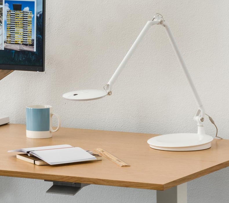A Humanscale Element Disc LED Task Light sitting on a desk