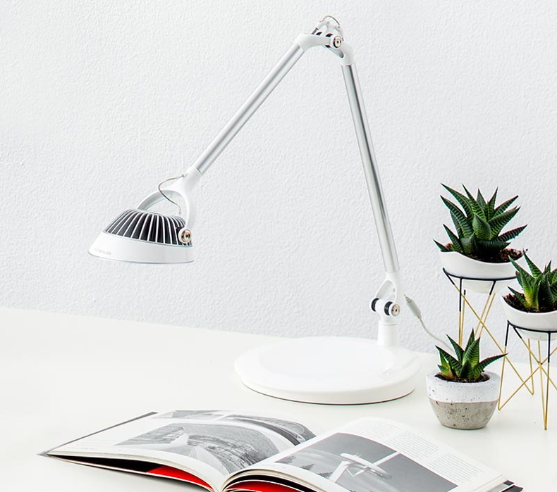 A white Humanscale Element Vision LED Light sitting on a desk