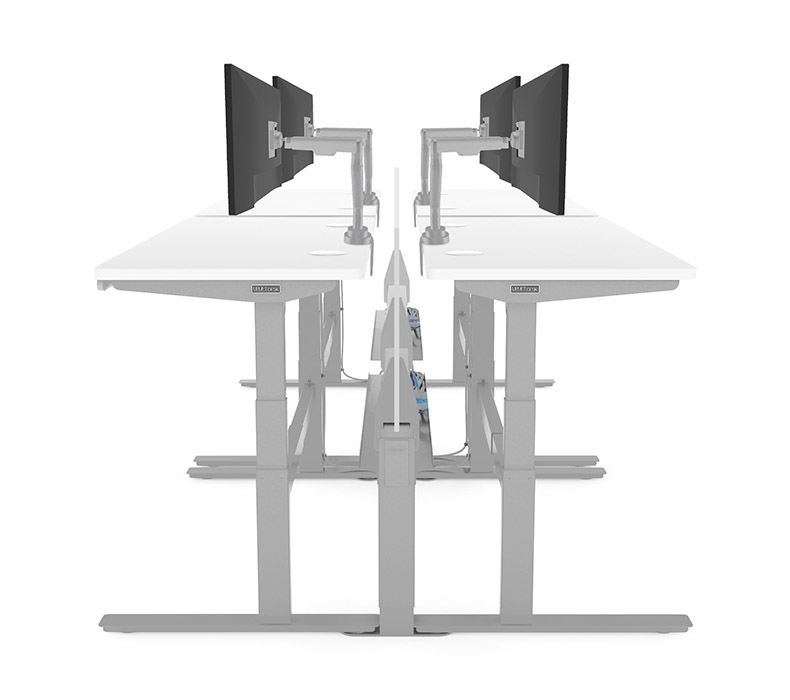 A dual row of height adjustable desks connected by Power & Data Rails