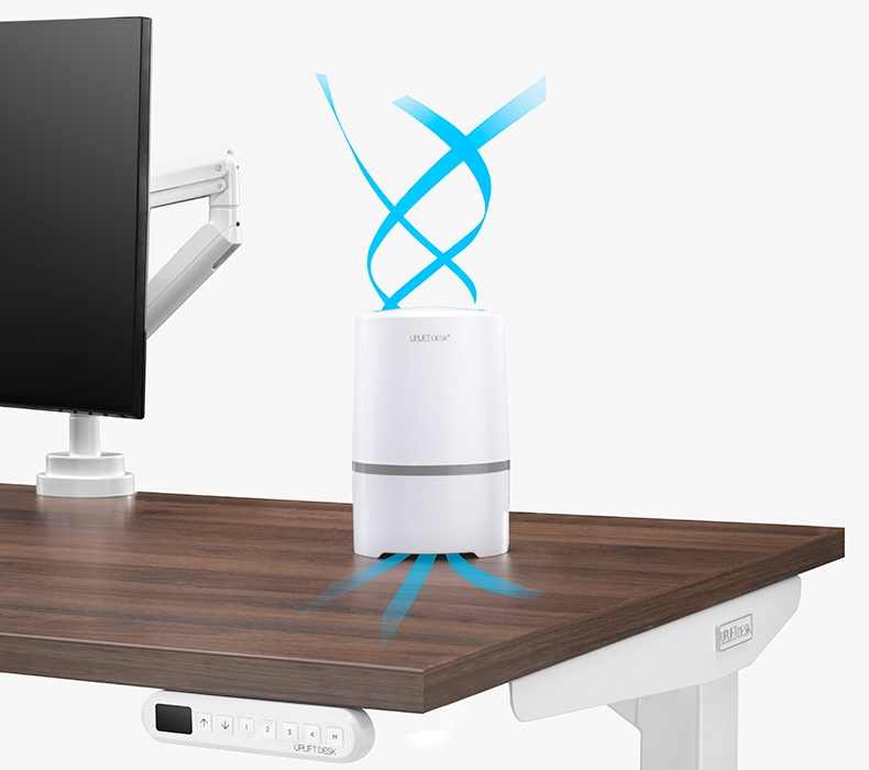 A Desktop Air Purifier on top of a standing desk with blue lines indicating air flow