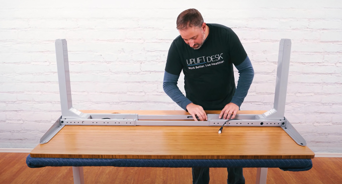 An UPLIFT Desk Employee assembles an UPLIFT Sit-Stand Desk