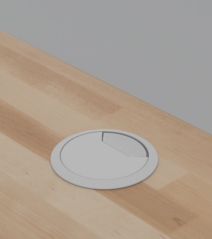 A white grommet cover on a Birch Butcher Block desktop.