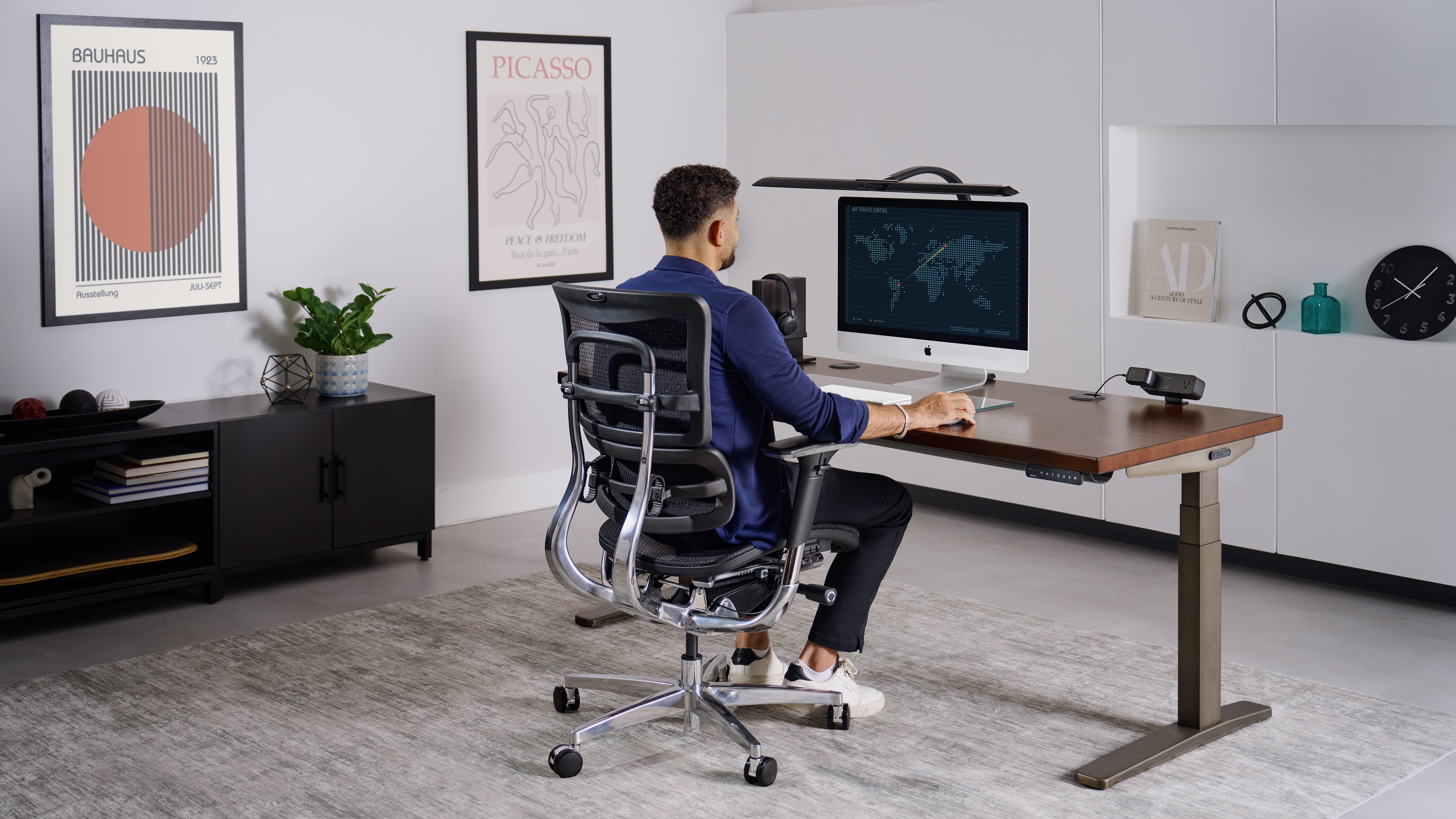 Person sitting and working at an uplift standing desk.