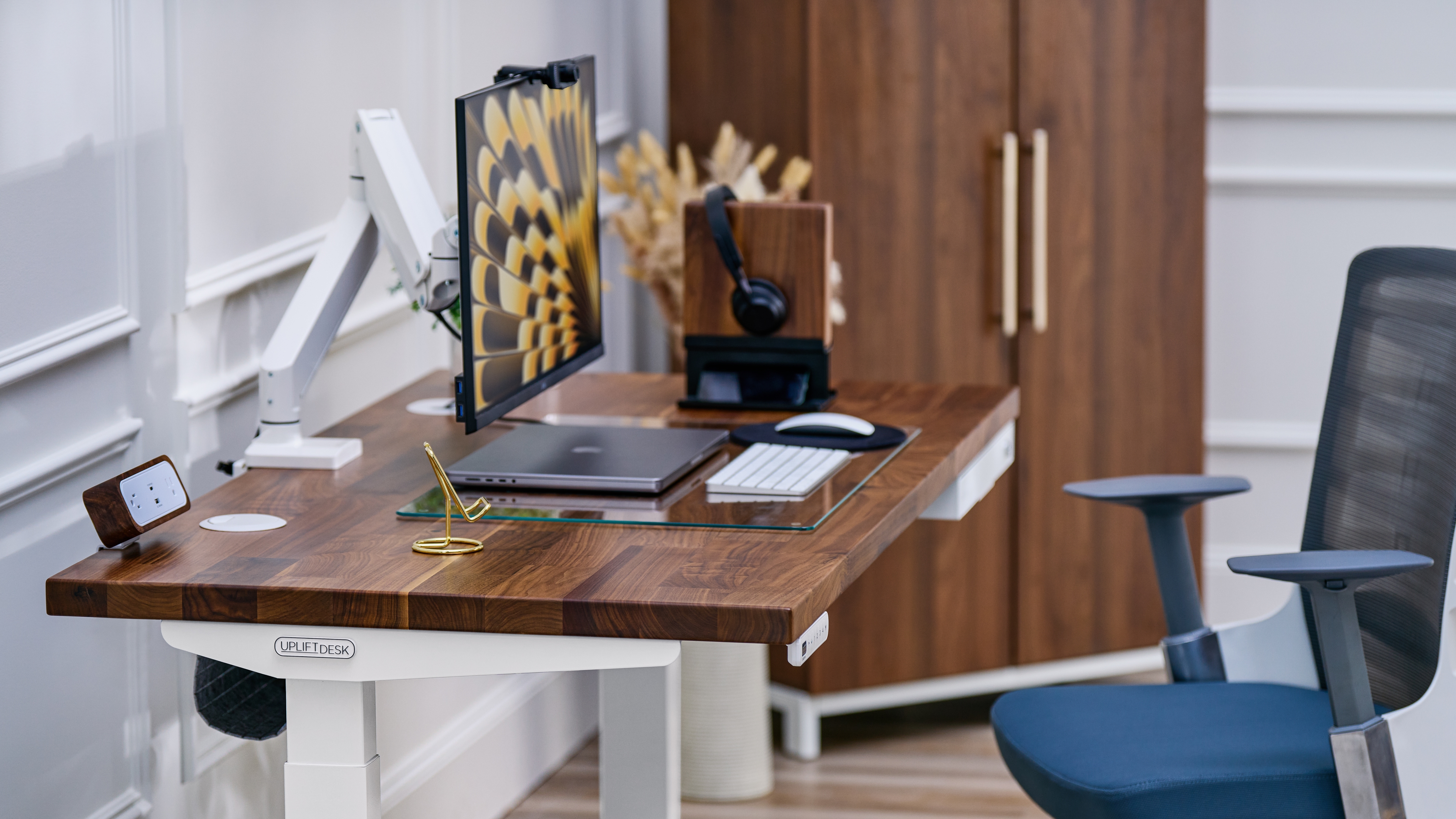 Uplift standing desk with walnut butcher block desktop in a home office environment.