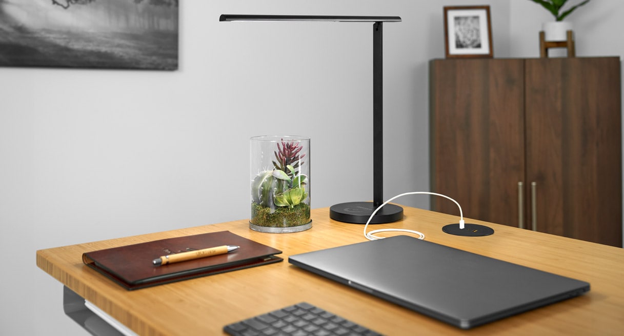 A Pop Up Power Grommet charging a laptop on a Bamboo UPLIFT Standing Desk
