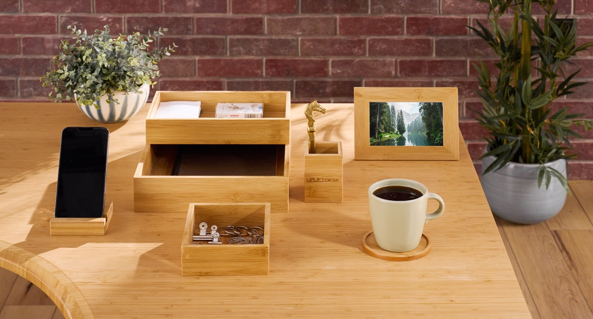 A bamboo standing desk with the standard bamboo color desk organizer and matching keyboard tray and bamboo drawer