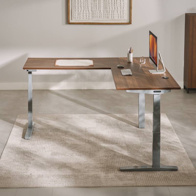 UPLIFT V3 3-Leg Standing Desk with gray frame and laminate desktop in a modern personal office setting