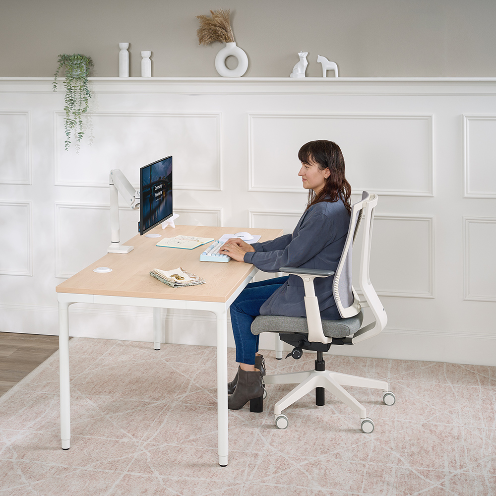 Person sitting in the Clarksville Ergonomic Chair by UPLIFT Desk in Fog at an UPLIFT Parsons Standing Desk