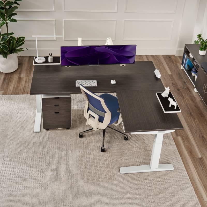 Overhead view of an UPLIFT V3 L-Shaped Standing Desk and UPLIFT Desk products in a small cohesive office