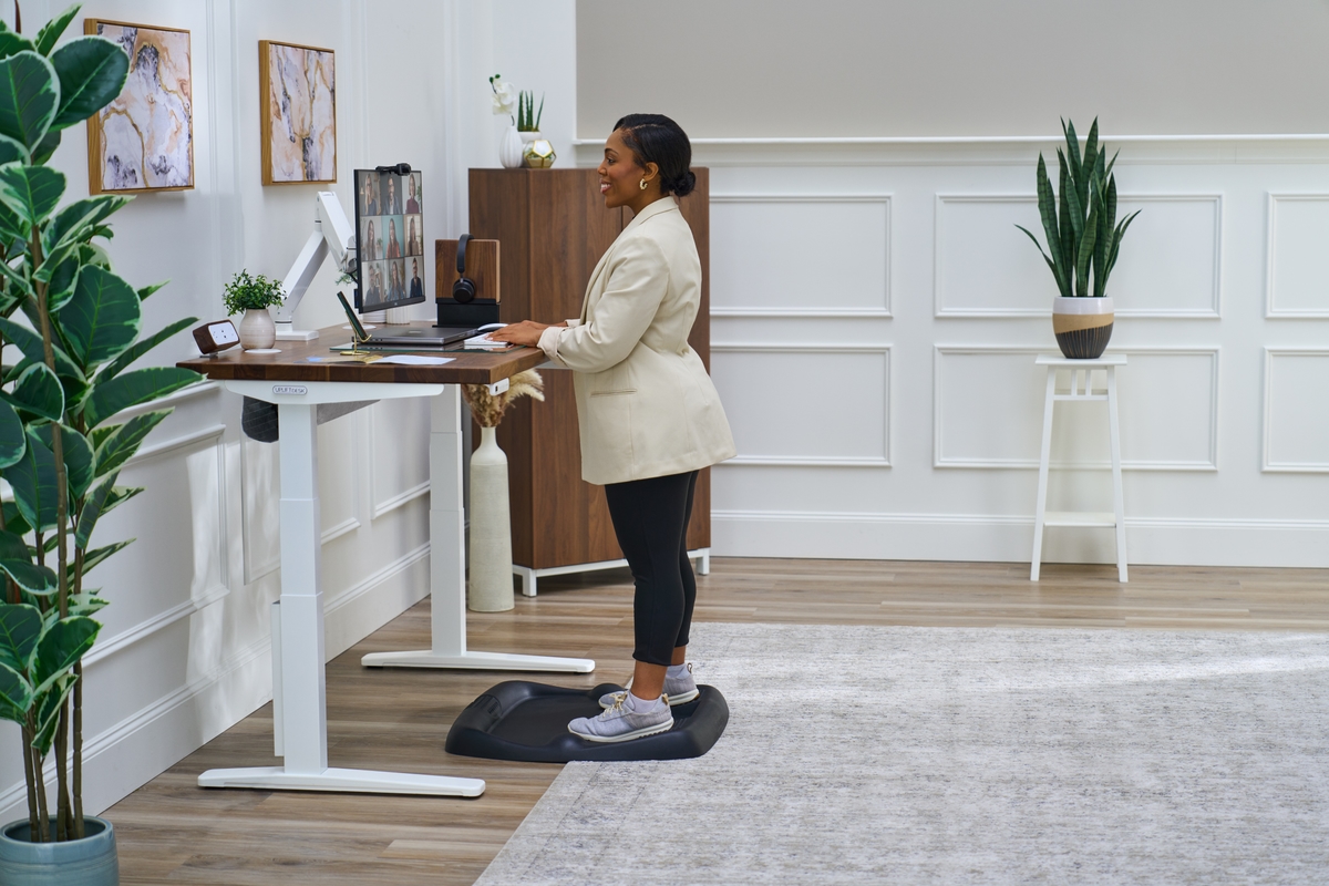 Person standing at an uplift standing desk working.