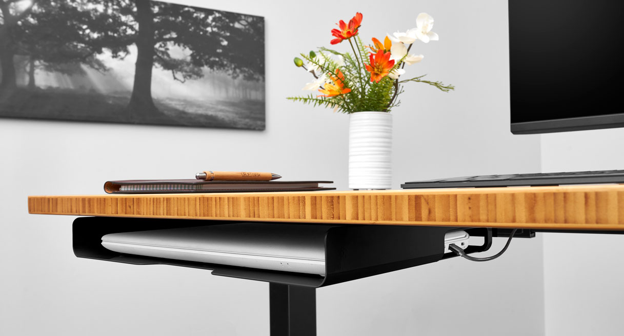 A low profile under desk shelf mounted beneath a Bamboo desktop viewed from the front