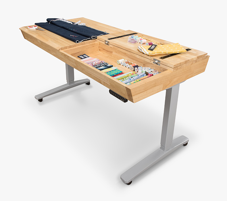 Fabric, thread, and other craft supplies laid on the Craft Table surface and in a compartment