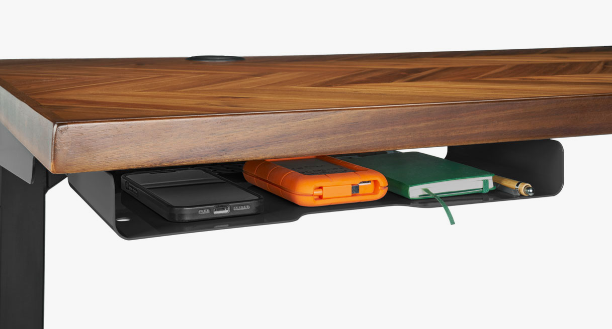A slim under desk shelf mounted beneath an Acacia Chevron Butcher Block desktop from the front