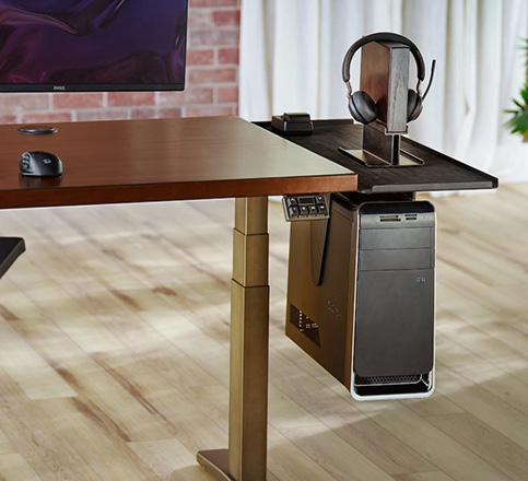 UPLIFT standing desk with a CPU holder attached to a desk extension, also featuring a headphone stand.