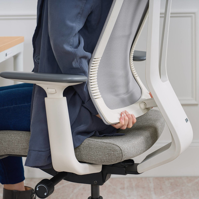 Person adjusting lumbar support on a Clarksville Drafting Chair