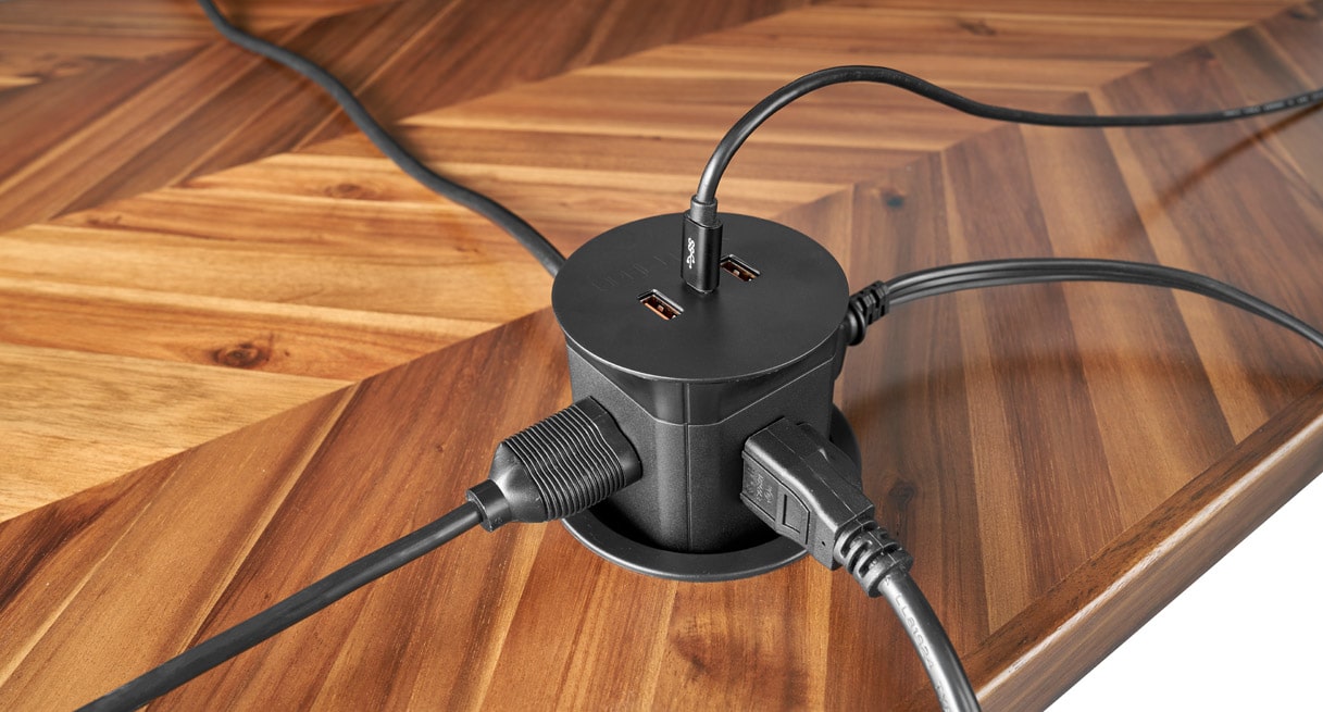 A Pop Up Power Grommet powering a laptop and a desk lamp on a Bamboo UPLIFT Sit Stand Desk