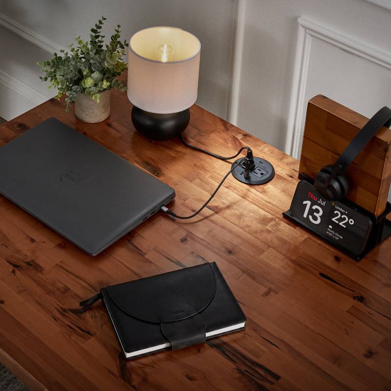 A Power Grommet with USB charging a laptop