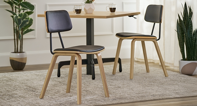 Kerbey Chair by UPLIFT Desk prominently featured in front of a Bistro table by UPLIFT Desk