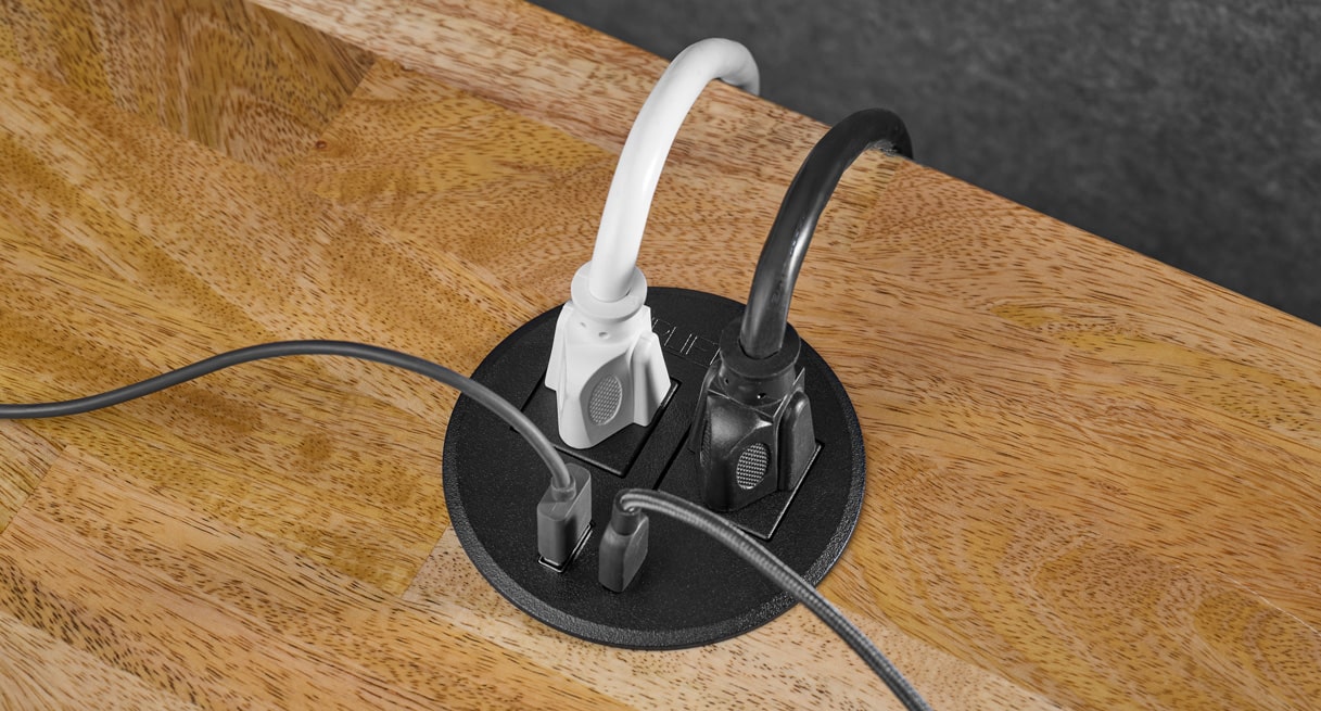 A Power Grommet with USB powering two devices via power outlets while charging two others via USB