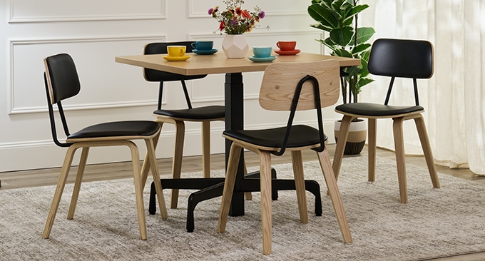 Four Kerbey chairs positioned around a Bistro table by UPLIFT Desk