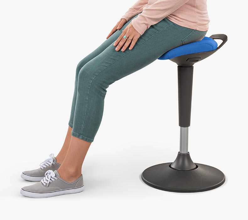 A woman sitting on a blue Starling Stool by UPLIFT Desk