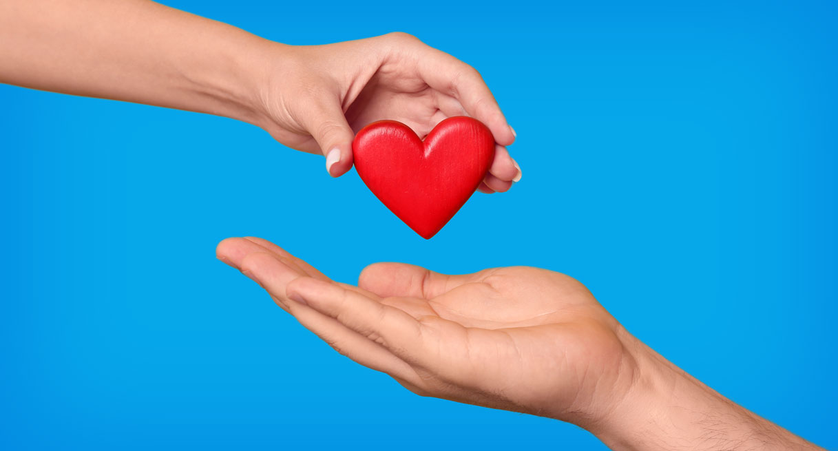 An illustration of a hand placing a heart in another person's hand
