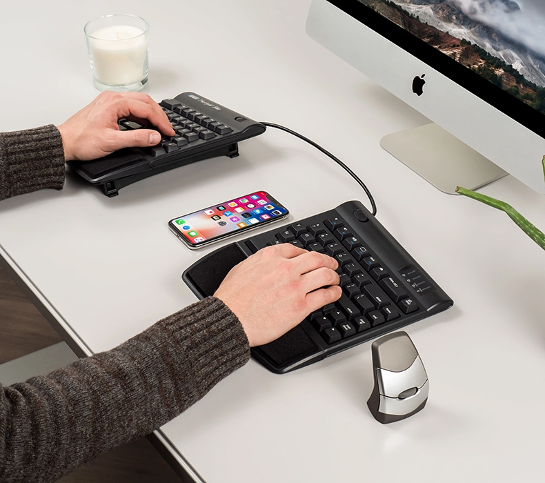 Arms positioned ergonomically while typing at a desk, featuring a Kinesis Adjustable Split keyboard.