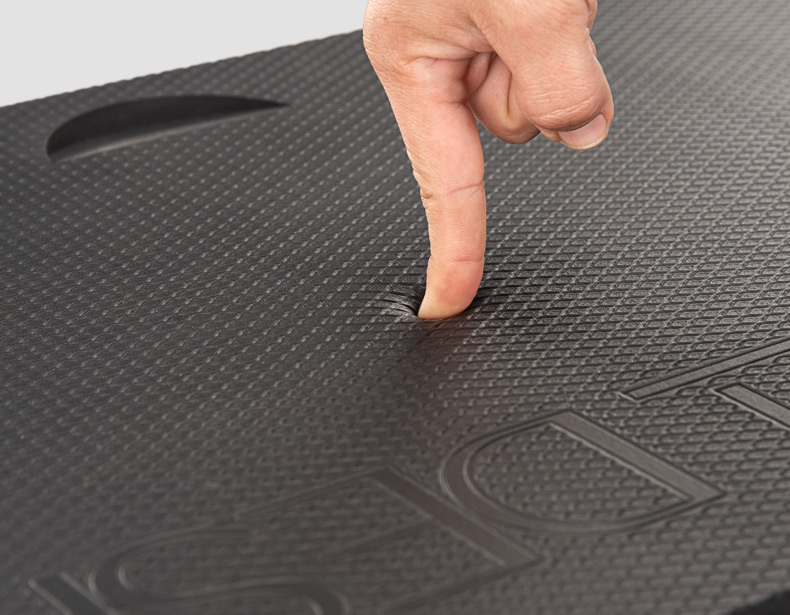Someone pressing a finger into the gel comfort mat to show its anti-fatigue cushioning