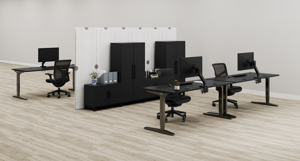 A black MoPac Wardrobe and Cabinet configuration creates a partition between two rows of matching black UPLIFT Standing Desks