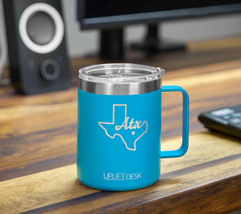 A close-up of a blue insulated mug on top of a Pheasantwood Solid Wood Desktop