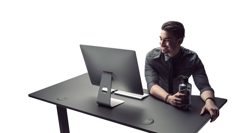 A man enjoys work at a fully optimized ergonomic desk with Eco Curve desktop.