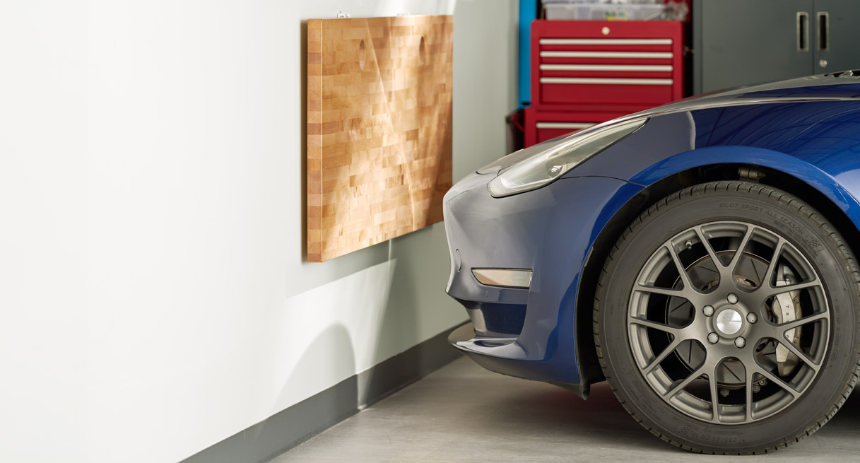 The floating table folded down to make room in a garage with a parked car