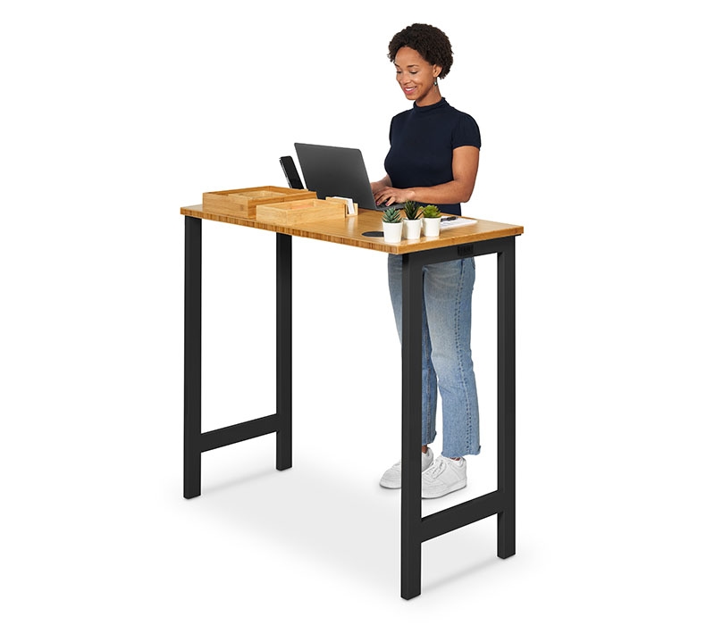 A person working at an UPLIFT Standing Height 4-Leg Table