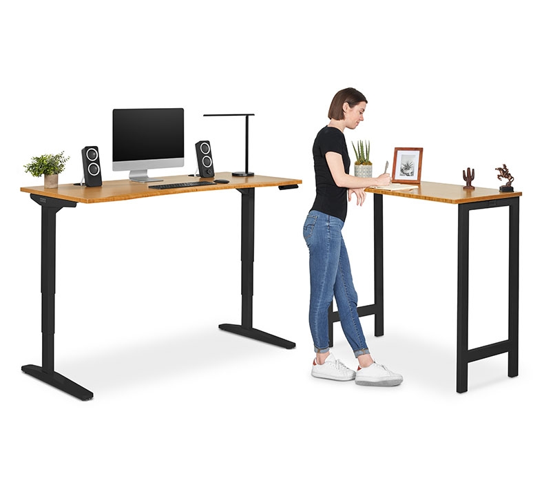 A person works at an UPLIFT Standing Height 4-Leg Table