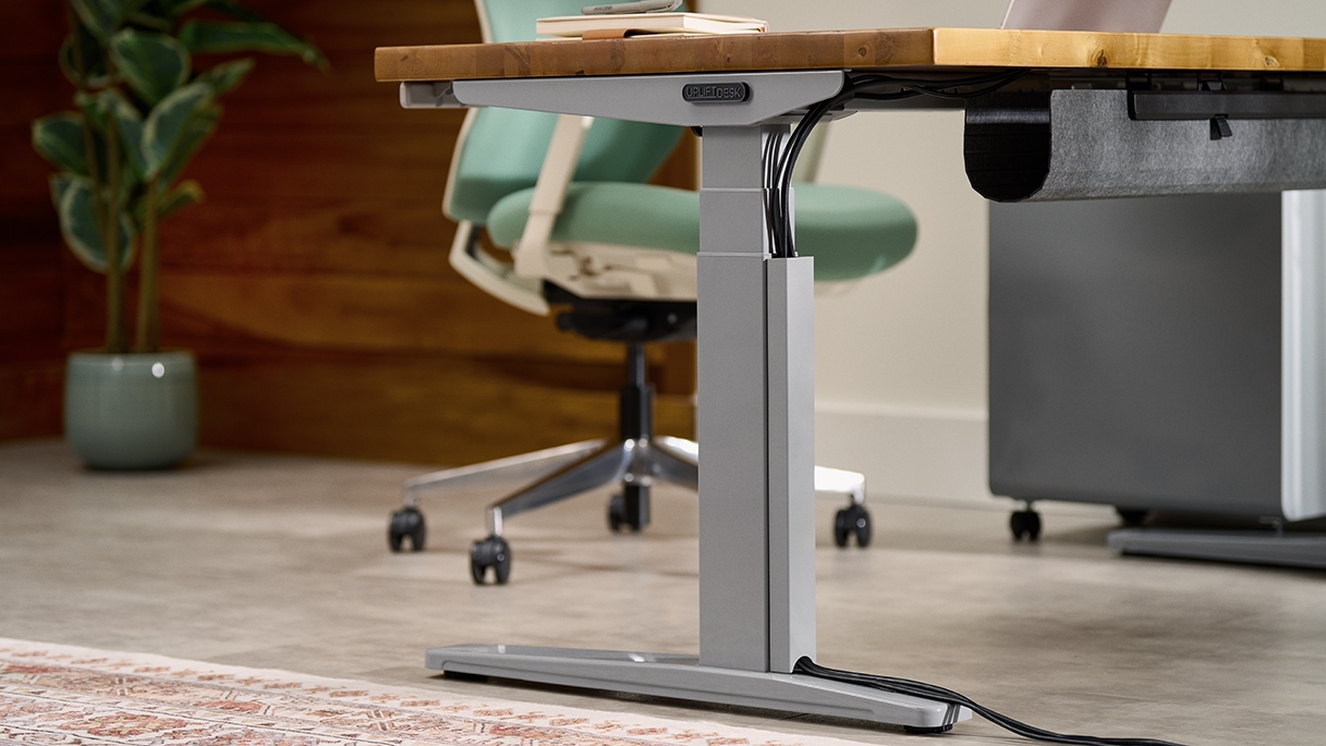UPLIFT Desk gray frame leg shown with Magnetic Cable Channel in matching finish for neat, cohesive design