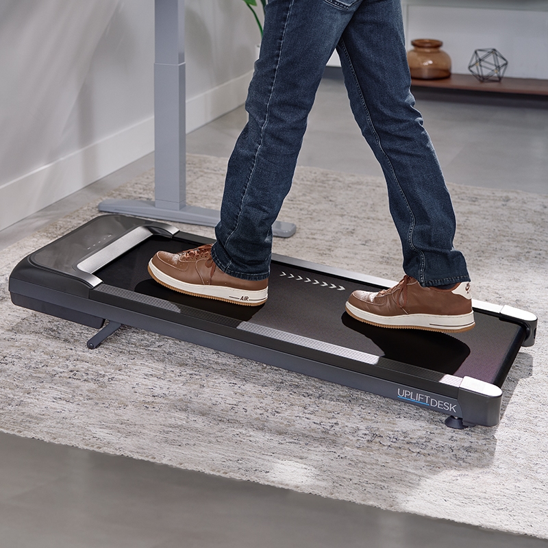 Inclining portable walking pad in use, showing only the lower body