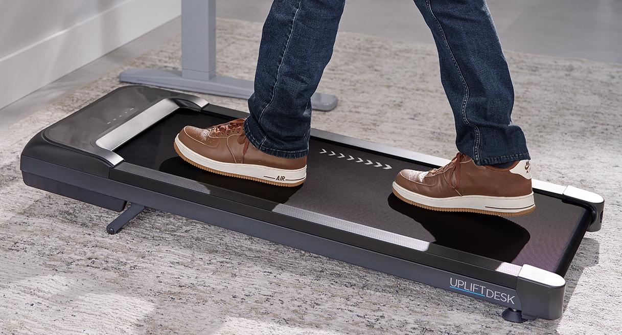 Inclining portable walking pad in use, showing only the lower body