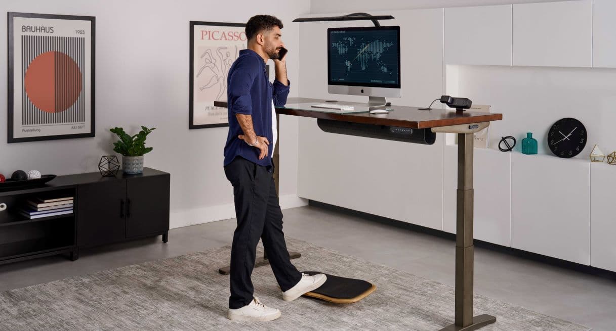 Person talking on their phone while working at a height-adjustable desk