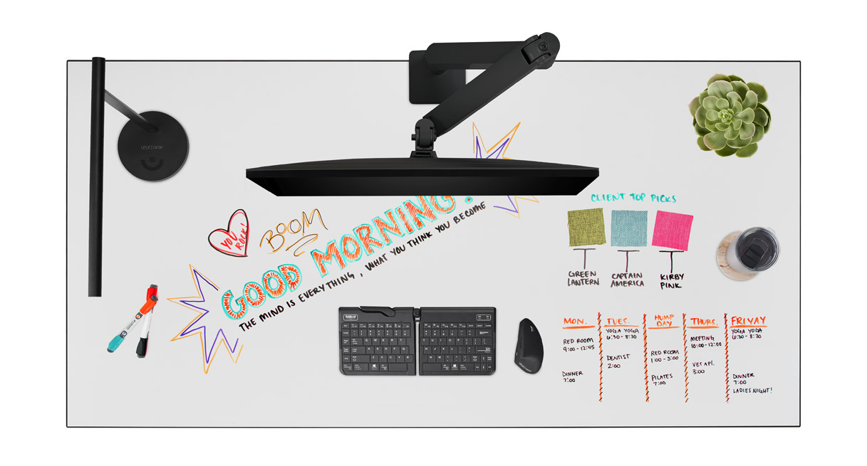 Whiteboard desktop with desk accessories and colorful writing.