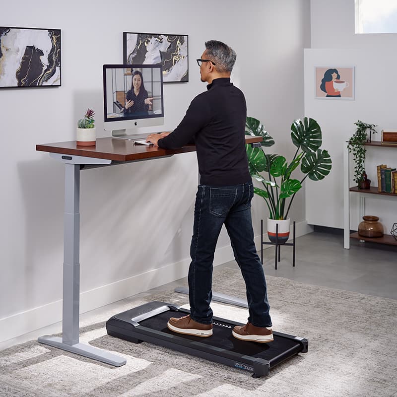 Person walking while working at a standing desk