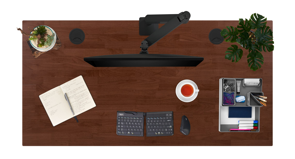 Dark rubber wood solid wood desktop with assorted desk accessories.