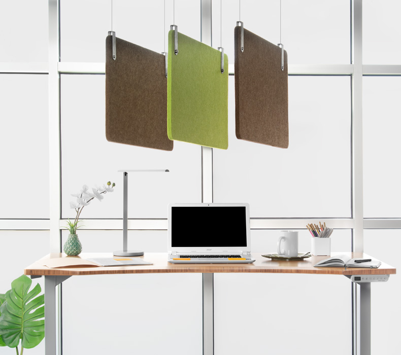 Acoustic panels hang from above a standing desk to offset ambient noise