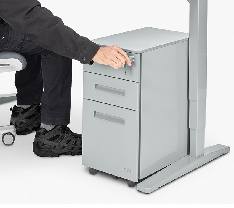 A man locks the drawers of an UPLIFT 3-Drawer Narrow Square File Cabinet