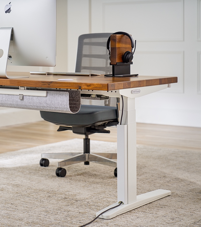 An Uplift Standing Desk with a Magnetic Cable Channel to protect and gather power cords.