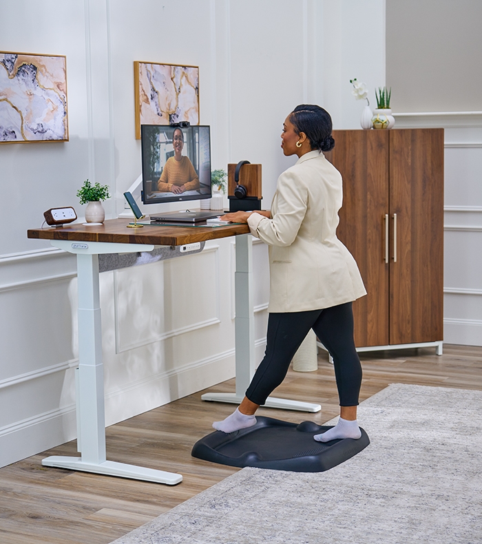 Person standing on an Active Anti-Fatigue mat at an Uplift Standing Desk.