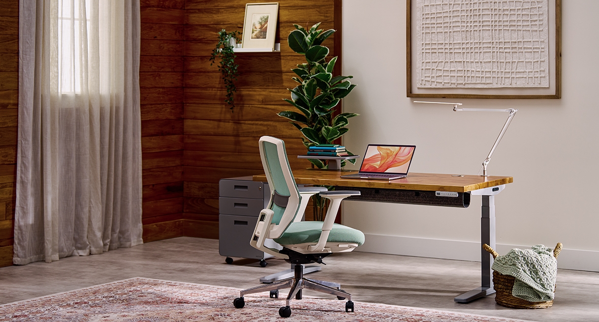 Uplift Standing Desk in Gray with a Reclaimed Birch Butcher Block desktop in a cozy office setting