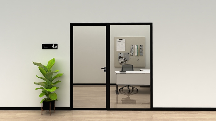 Glass door revealing an L-shaped UPLIFT Desk in a neatly organized office.